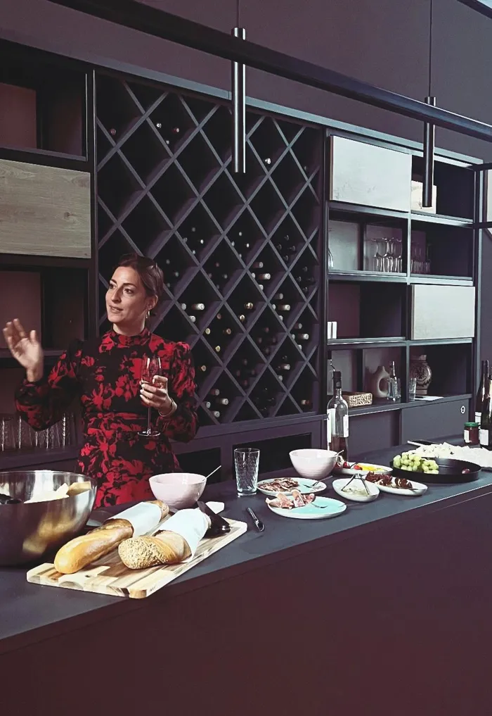 Hannah moderiert ein Käse- und Weintasting vor einer Weinwand