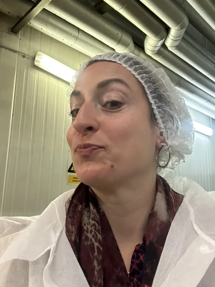 Hannah mit Haarnetz bei einem Besuch in einer Käserei