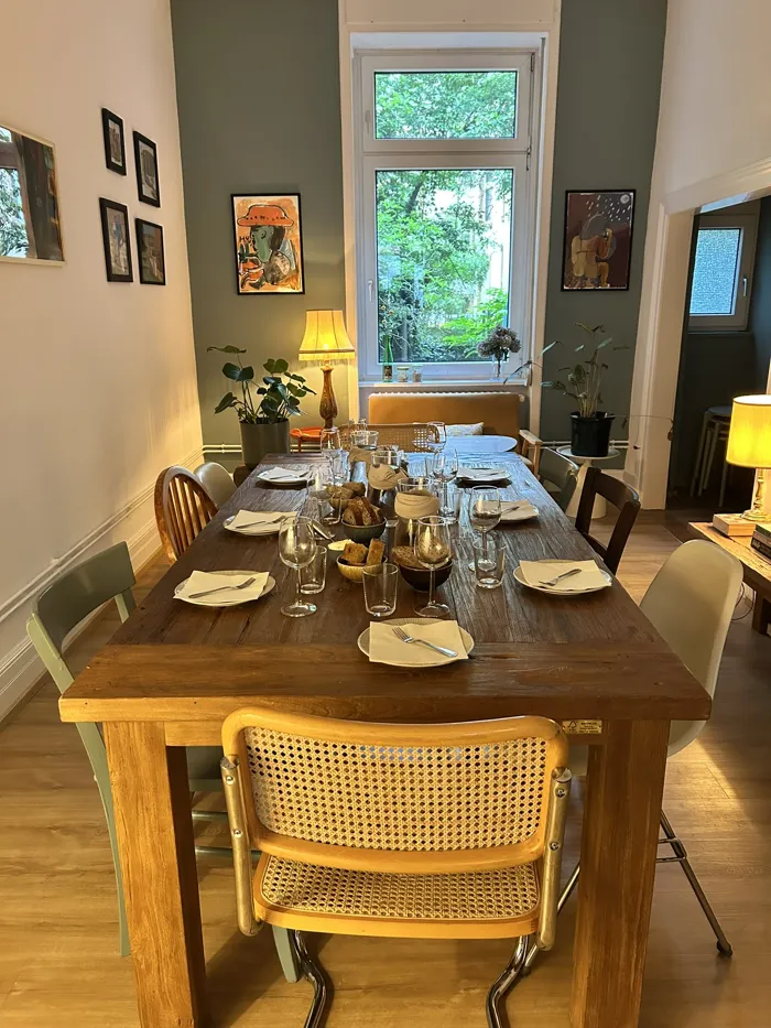 Gedeckte Holztafel mit Kerzen und Gläsern für den Supper Club